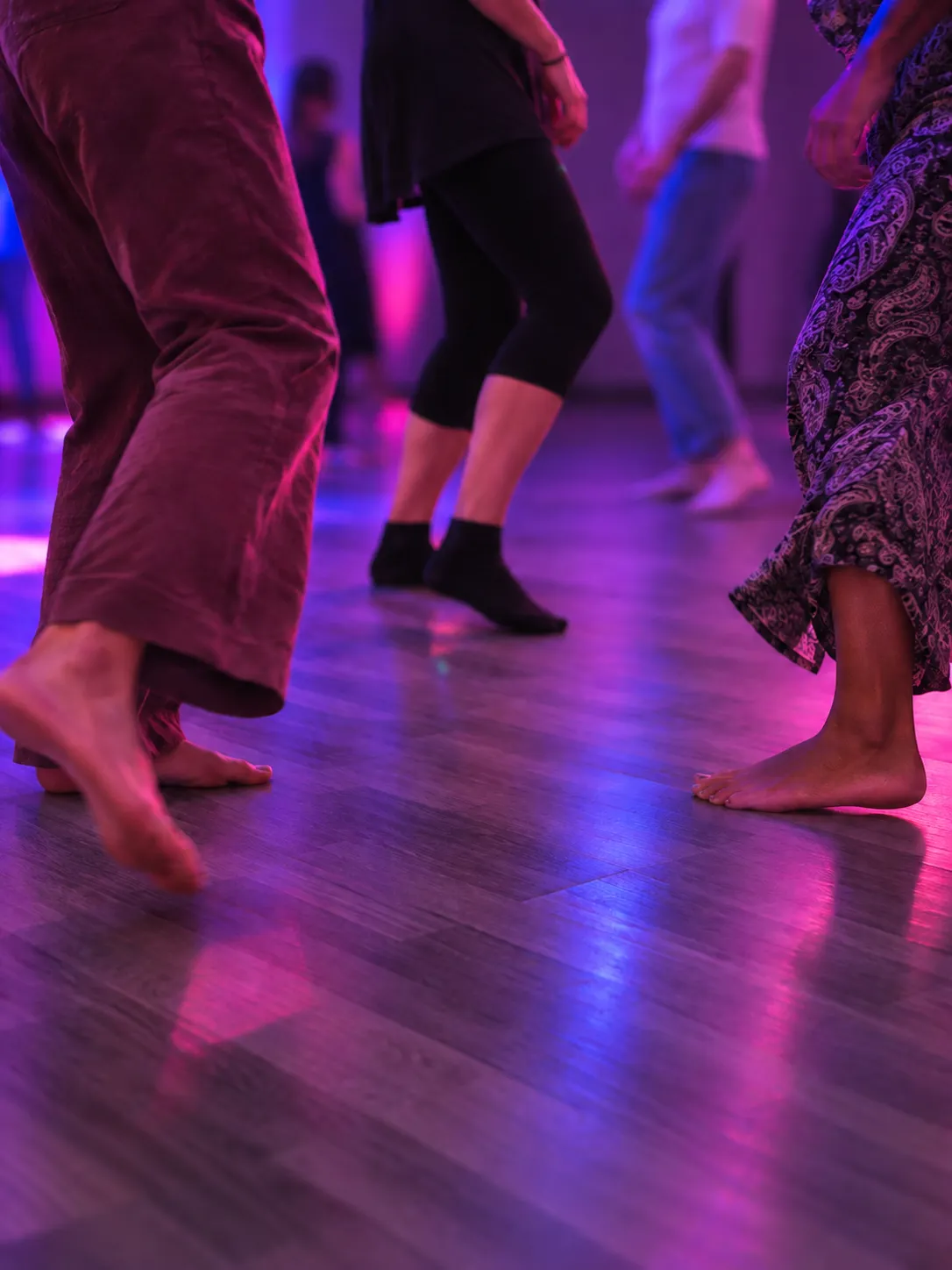 Des participants dansent ensemble sous les lumières colorées